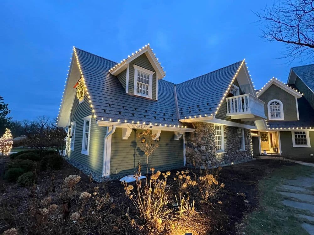 Charming house adorned with festive lights during twilight, showcasing cozy holiday spirit.